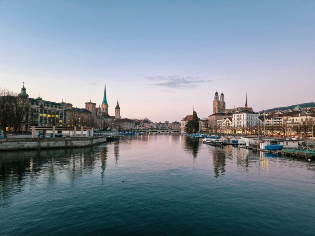 pexels-photo-37133703-37133703 Beautiful evening view of Zürich's skyline with the river reflecting illuminated historic architecture.